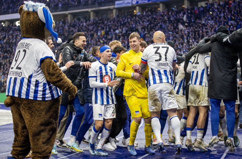 Berlins Reese trifft im Elfmeterschießen zum 5:3 und die Mannschaft feiert mit ihren Fans den Sieg.