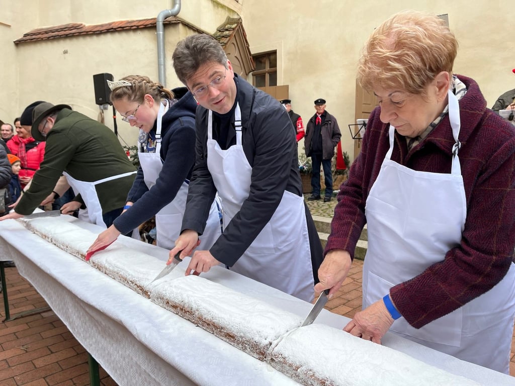 Robert Reck und Christa Müller schnitten mit Mitstreitern den Roßlauer Weihnachtsstollen an und verteilten ihn innerhalb weniger Minuten unter den hungrigen Besuchern.
