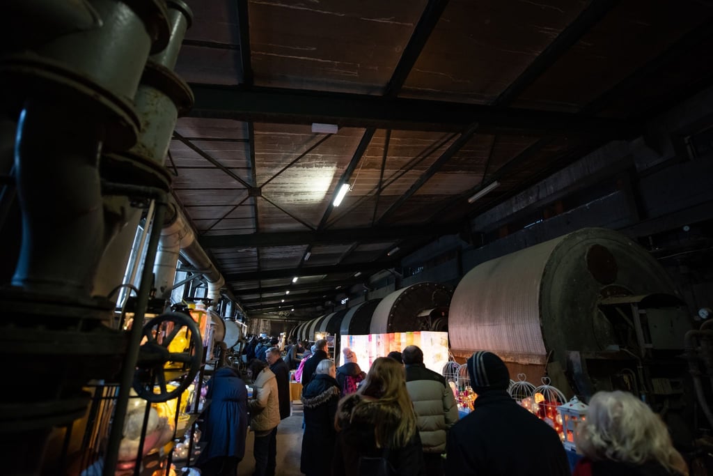 Besucher gehen über den Weihnachtsmarkt in einer ehemaligen Erzaufbereitungsanlage im Weltkulturerbe Erzbergwerk Rammelsberg.