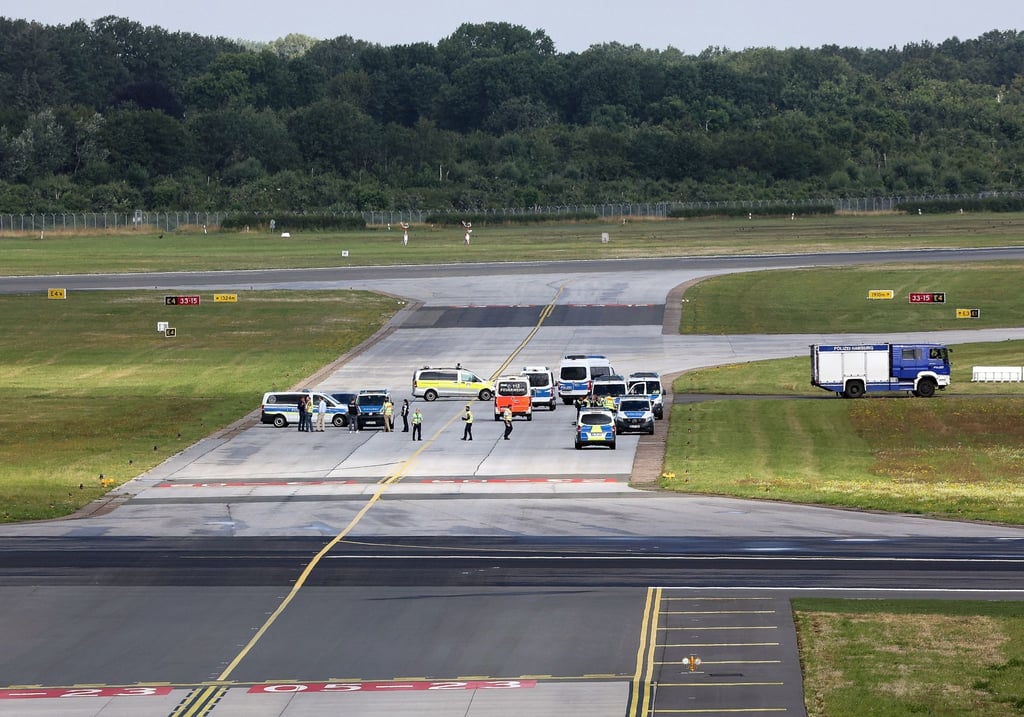 Einsatzkräfte der Polizei stehen auf einem Rollfeld des Hamburger Flughafens.