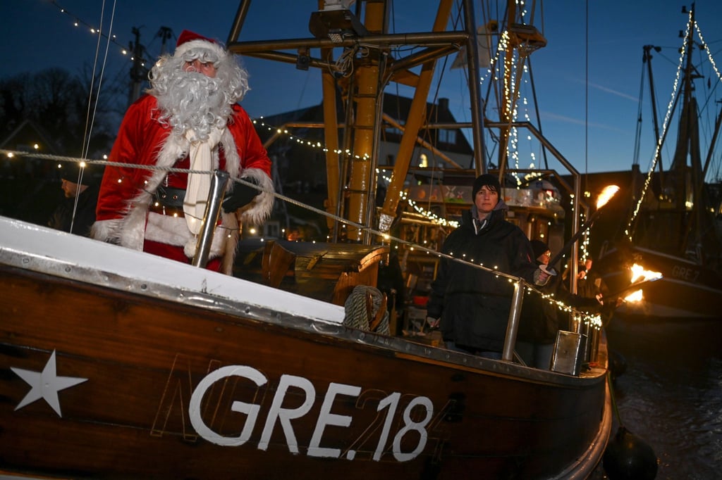Der Weihnachstsmann kommt mit einem Fischkutter im Hafen an.