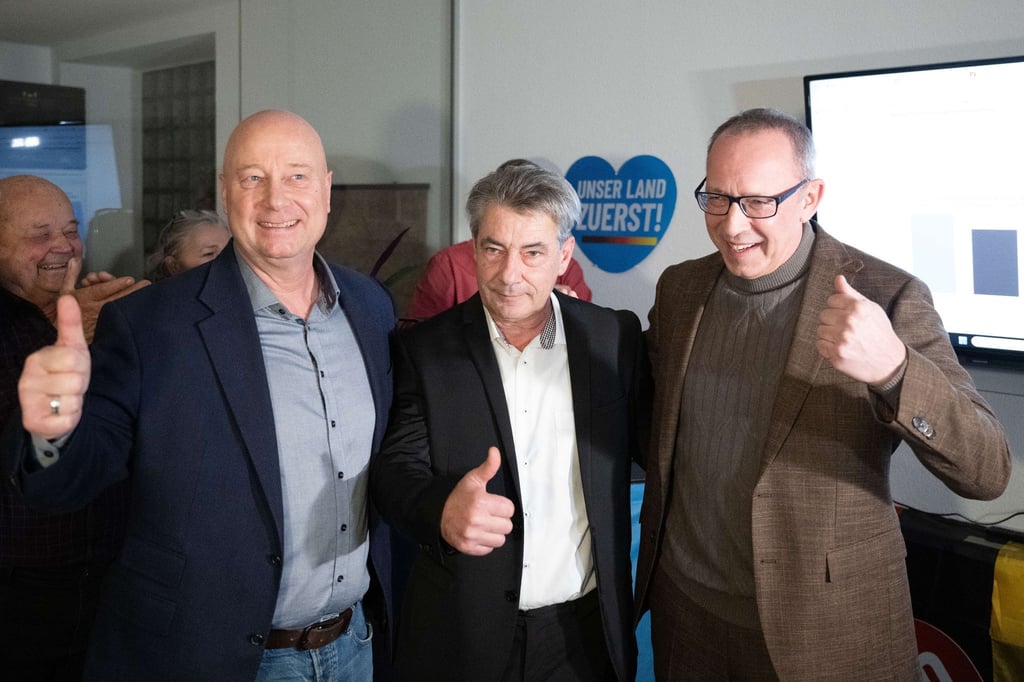 Der sächsische AfD-Generalsekretär Jan Zwerg (l-r), AfD-Kandidat Tim Lochner und der sächsische AfD-Vorsitzende Jörg Urban jubeln während der Wahlparty ihrer Partei.