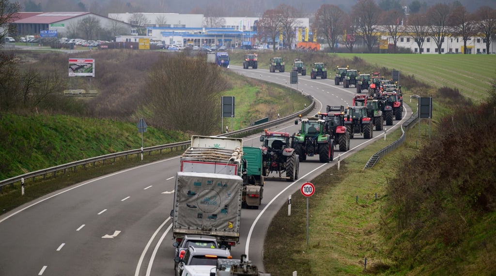 Landwirte fahren mit ihren Traktoren im Schritttempo über Bundesstraße 4 bei Uelzen.