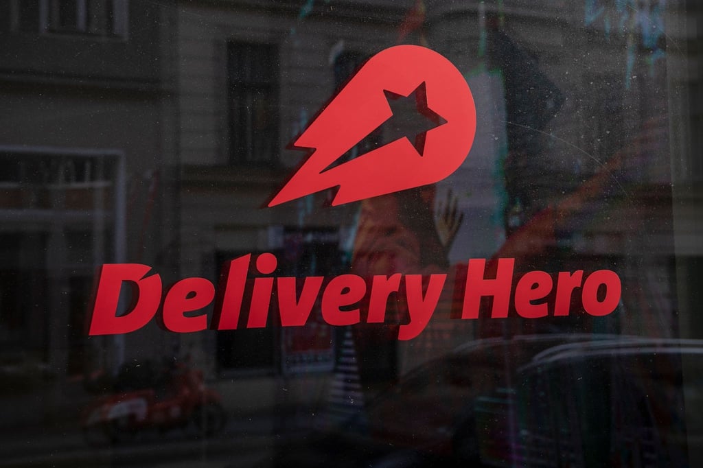 Das Logo und der Schriftzug des Essenslieferdienstes Delivery Hero auf einer Scheibe.