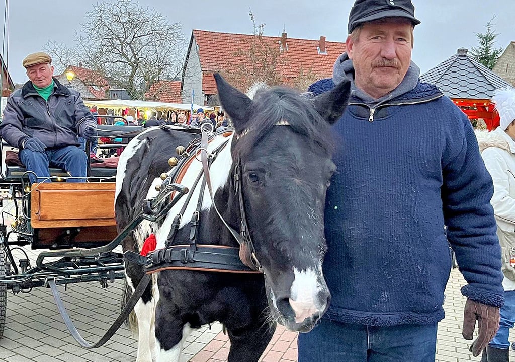 Rainer Dreusicke bringt von Beginn an mit seinem Pferd und Kutsche den Weihnachtsmann zum Markt. Begleitet wird er dabei von Toralf Lipke (vorn).