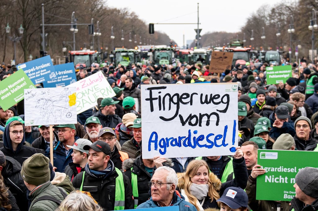 Auf der Demo des Deutschen Bauernverbandes hält jemand ein Schild „Finger weg vom Agrardiesel“ hoch.