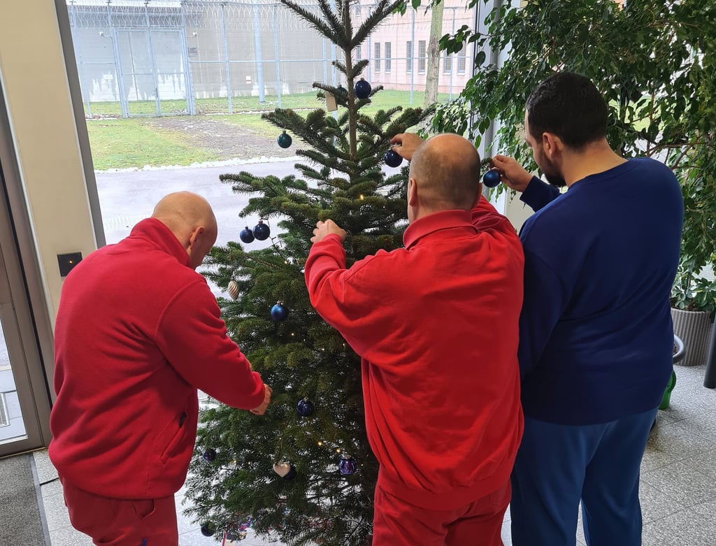 Die Strafgefangenen Ralf, Thomas und Edgar schmücken in der Burger Haftanstalt einen Weihnachtsbaum.
