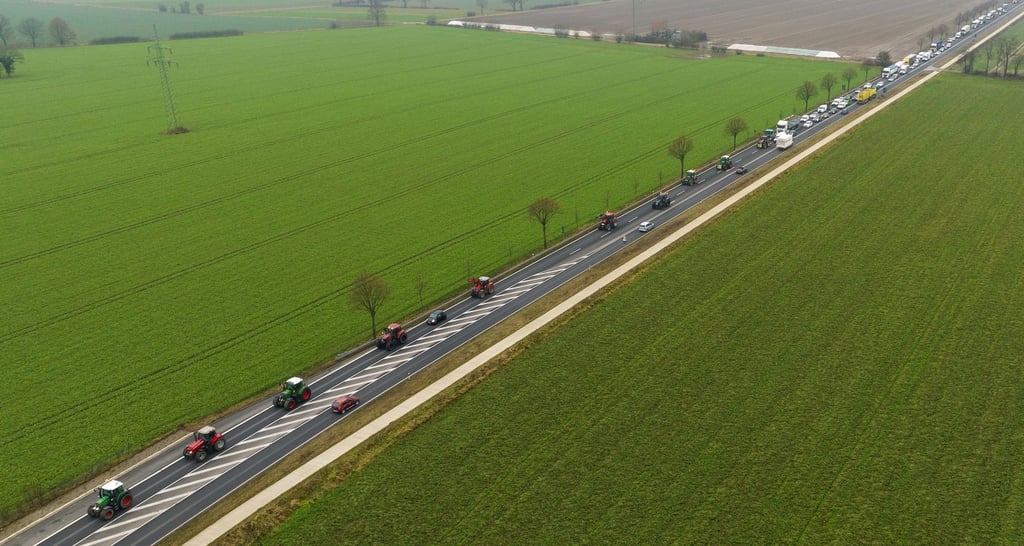 Landwirte fahren mit ihren Traktoren im Schritttempo über eine Bundesstraße.