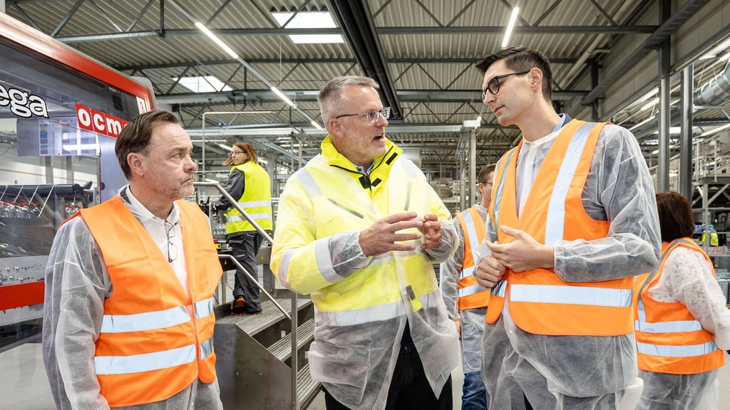 Betriebsleiter Jens Strassner erläutert Sepp Müller (r.) und Michael Jahn (l.) die hochautomatisierte Produktion.