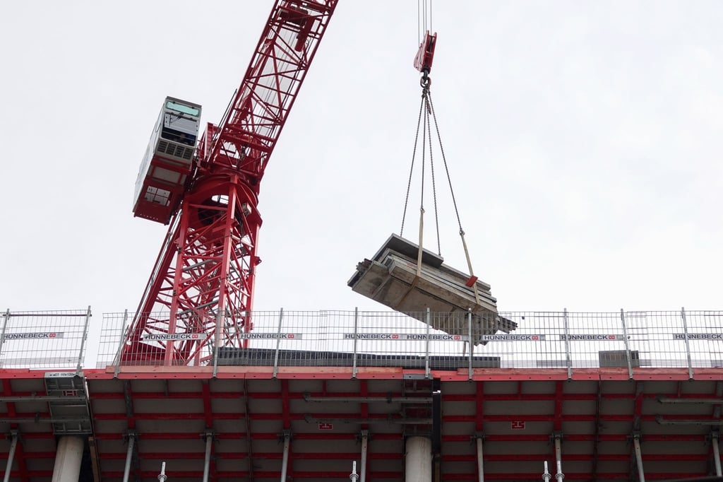 Ein Kran transportiert Baustoffe auf einer Baustelle.