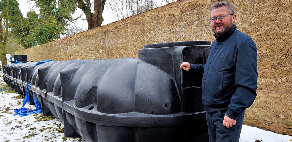 Der Bau- und Ordnungsamtsleiter der Verbandsgemeinde Egelner Mulde, Sascha Josuns, zeigt die riesigen Kunststoffteile für die neue Löschwasserzisterne in Wolmirsleben.