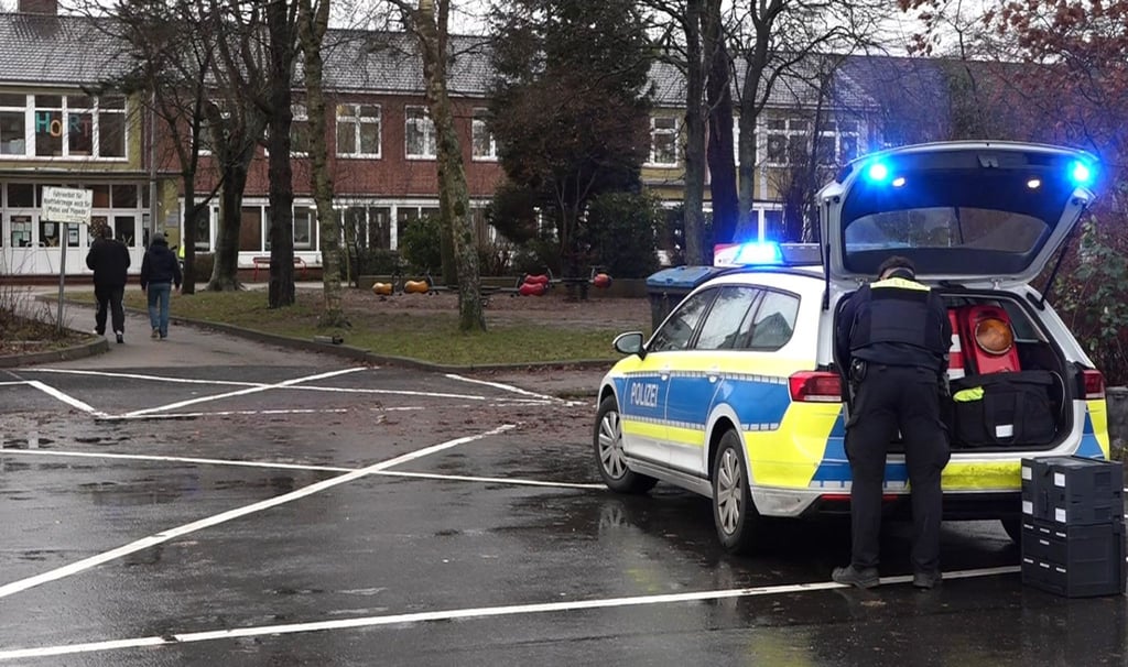 Ein Polizeiauto steht vor dem Gebäude einer Grund- und Hauptschule in Lüdingworth. Dort hat ein Mädchen ein anderes mit einem Messer schwer verletzt.