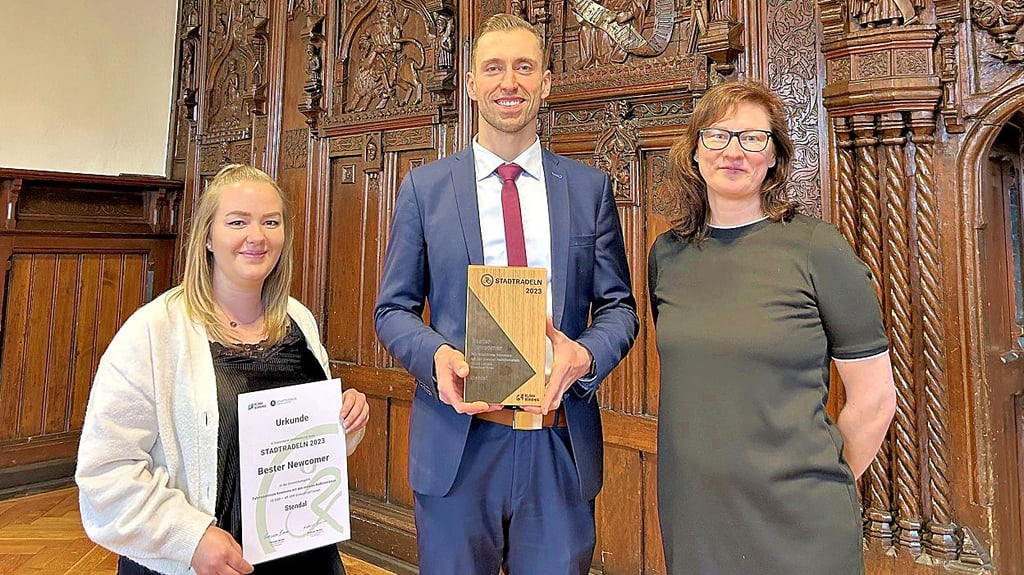 OB Bastian Sieler freut sich mit Florentine Gruppe (links) und Nicole Laupsien vom Veranstaltungsmanagement über die Trophäe.