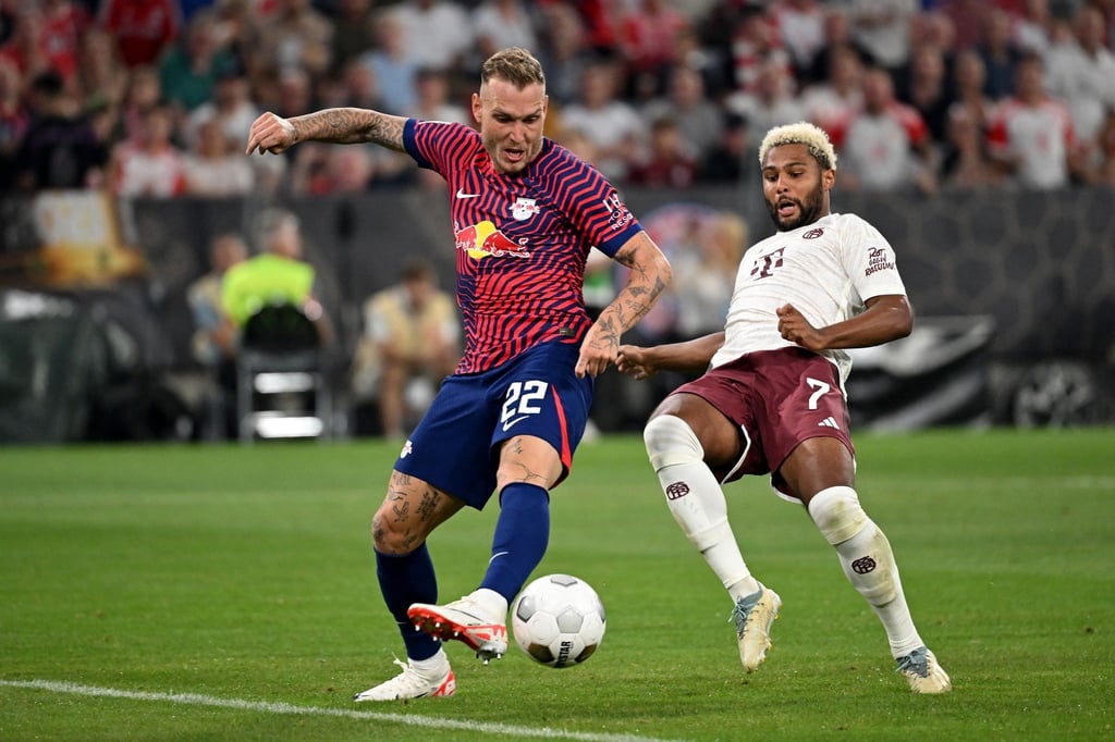 Leipzigs David Raum (l) und Bayerns Serge Gnabry kämpfen um den Ball.