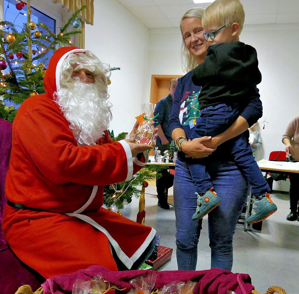 Der alte Geselle mit dem weißen Bart und dem roten Mantel verteilt auf dem Adventsbasar in Zörnigall eine süße Überraschung an die kleinen Besucher.