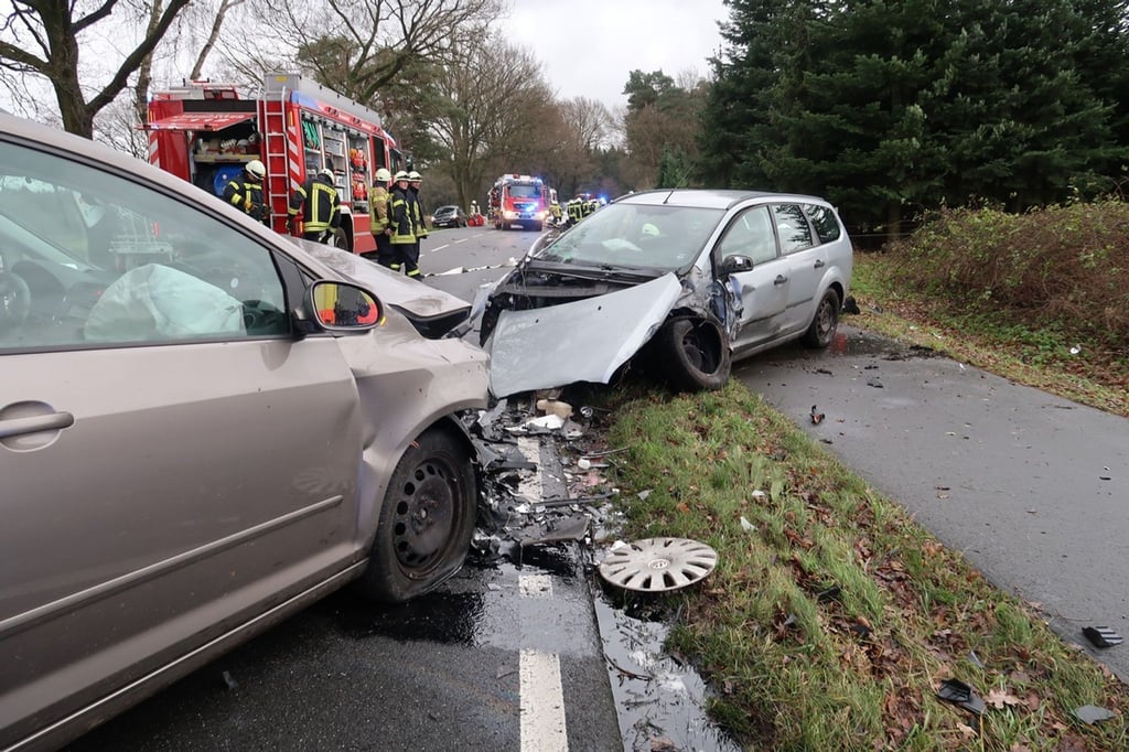 Nach einem Verkehrsunfall stehen zwei stark beschädigte Autos vor einem Feuerwehrwagen.