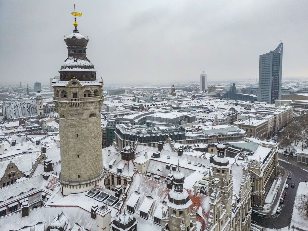 Schnee liegt auf Turm und Dächern des Neuen Rathauses.