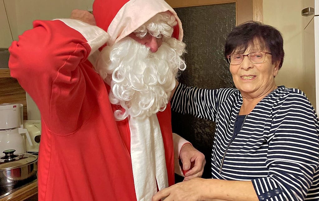 Ingrid Magnus putzt ihren Mann Alfred für einen Besuch als Weihnachtsmann heraus.