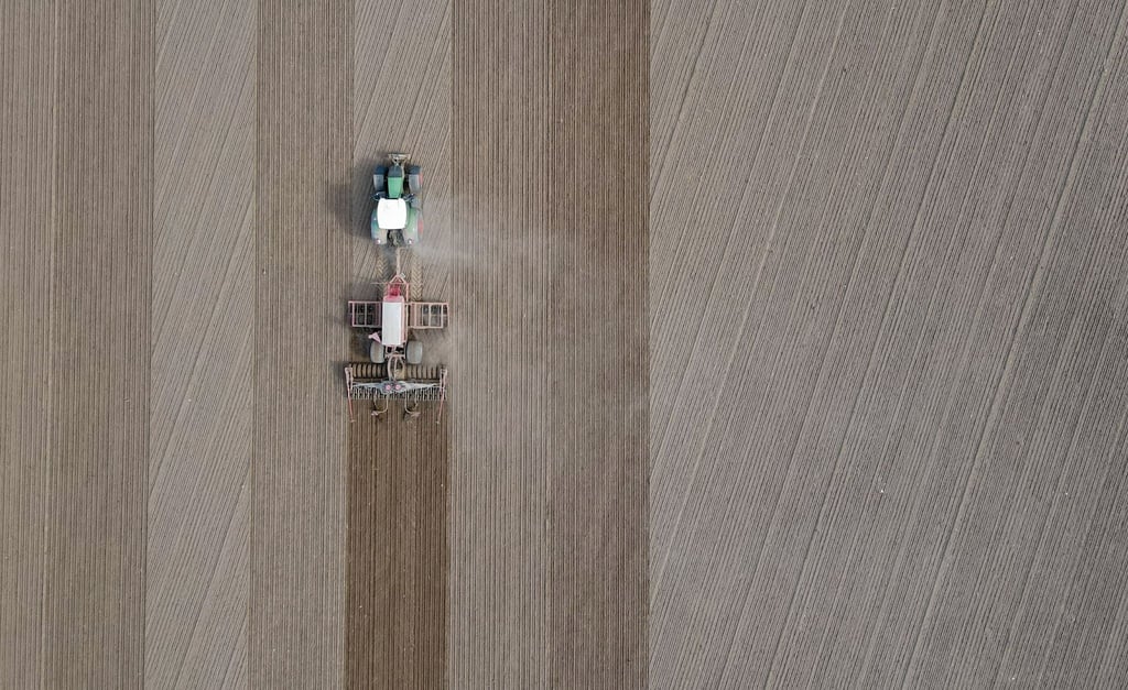 Ein Landwirt bringt Saatgut in den Boden aus.