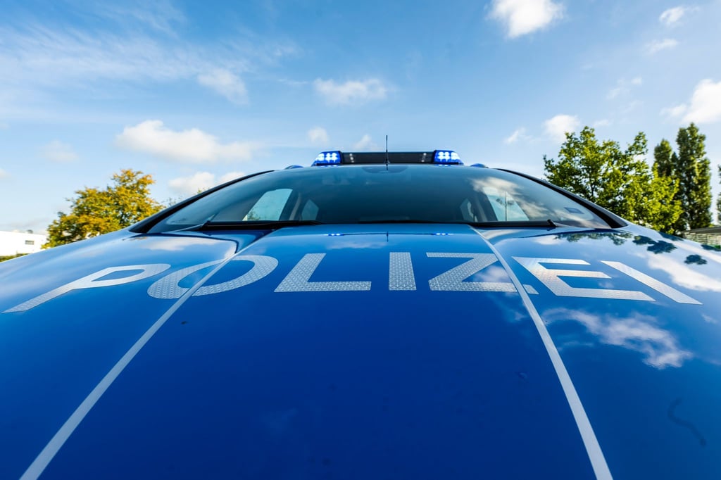 Auf der Motorhaube eines Streifenwagens steht der Schriftzug „Polizei“.