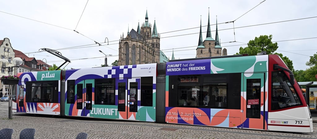 Das Leitwort des Katholikentags: „Zukunft hat der Mensch des Friedens“ ist auf einer Straßenbahn zu lesen.