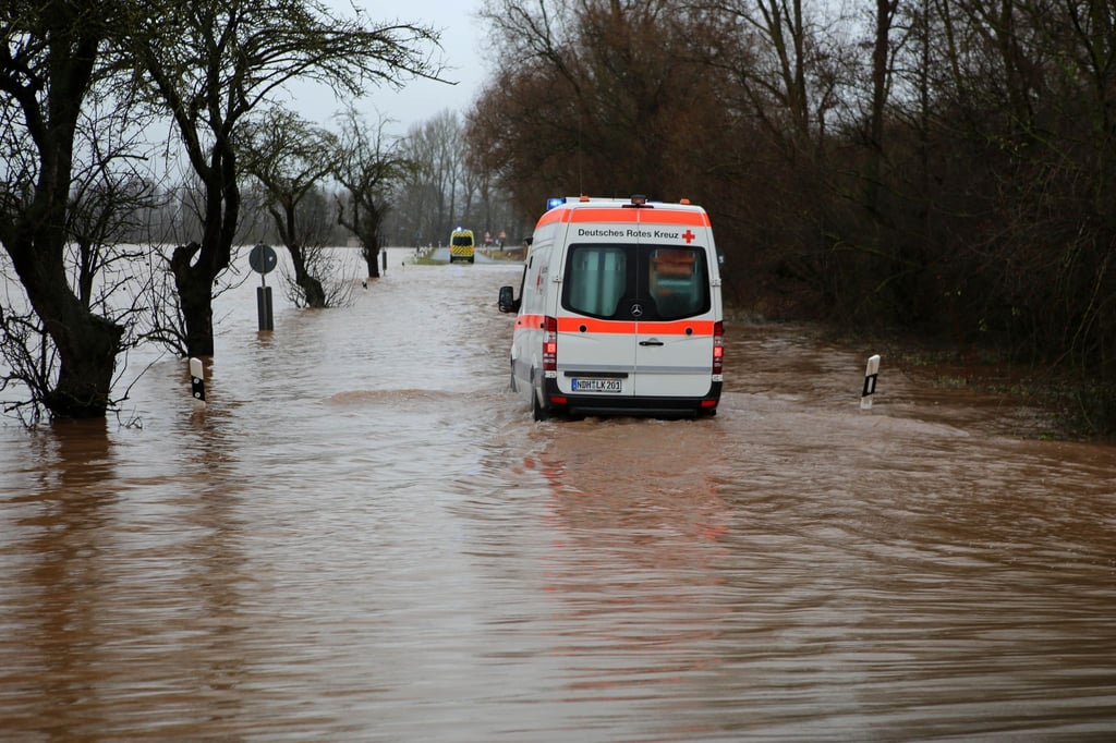 Ein Krankenwagen fährt über eine von Hochwasser überflutete Straße nach Windehausen.