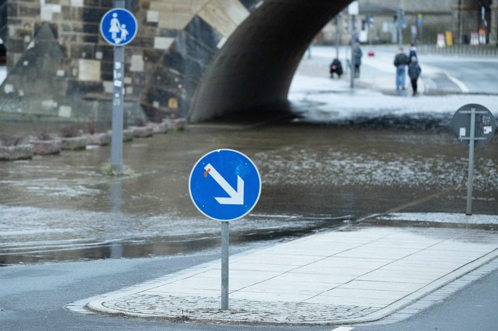Passanten stehen am Terrassenufer in Dresden an der Elbe.