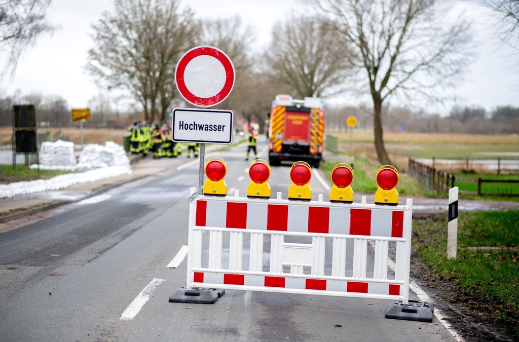 Eine Absperrbake und ein Schild mit der Aufschrift "Hochwasser".