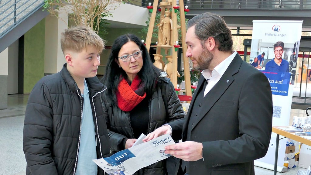 Toni Kaczor (rechts) erklärt Manuela Gehrmann und ihrem Sohn Lasse die Perspektiven, die das Unternehmen Tonfunk den jungen Menschen bietet.