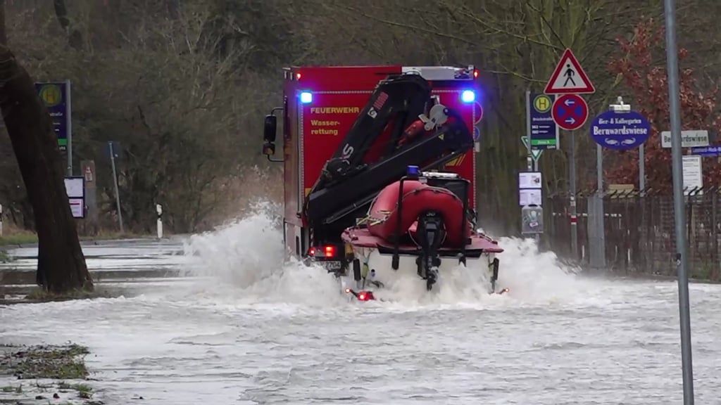 Die Wasserrettung der Feuerwehr Hannover fährt mit einem Boot über eine überflutete Straße.
