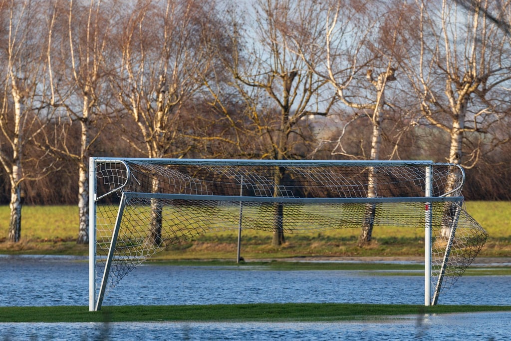 Ein Fußballplatz ist überschwemmt.