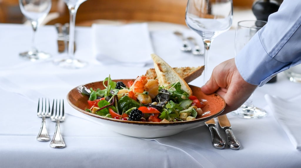 Ein Kellner serviert einen Salatteller in einem Restaurant.