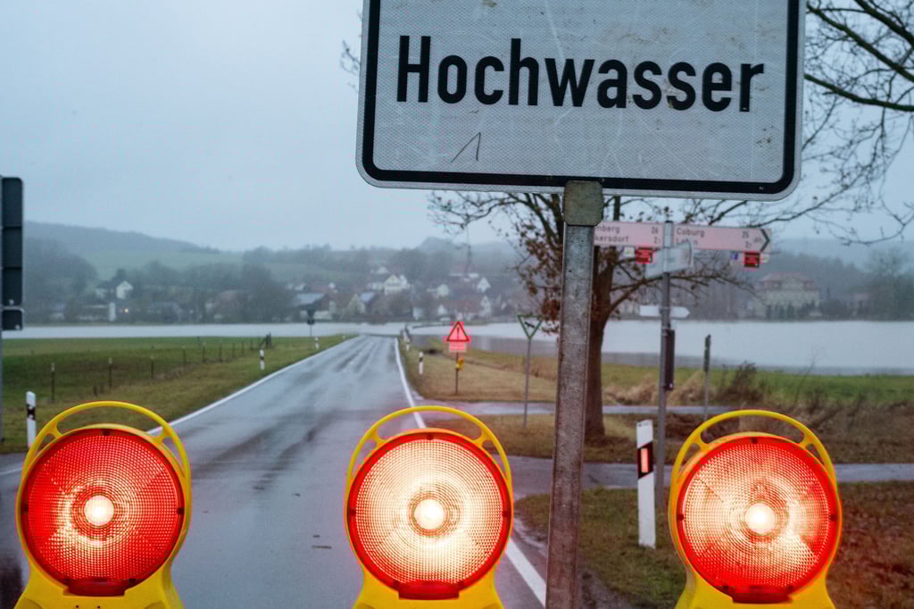 Ein Schild warnt vor Hochwasser, die Straße ist gesperrt.