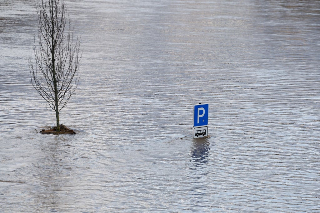 Eine Schild „Parkplatz für Busse“ schaut aus dem Hochwasser.