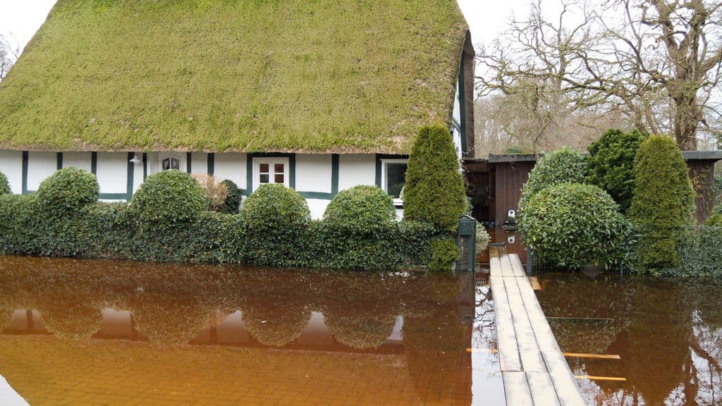 Bretter liegen zum Überqueren von Hochwasser vor einem Haus.