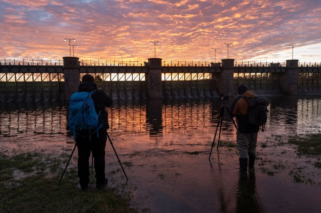 Die Hochwasserlage in Sachsen-Anhalt ist weiter angespannt: Pretzien: Zwei Fotografen stehen zum Sonnenaufgang am Pretziener Wehr.