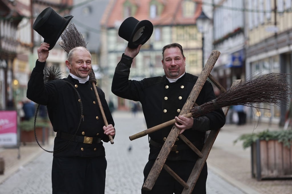 Die beiden Schornsteinfeger Thomas Schramm (l) und Gabor Mäntz sind unterwegs und verteilen Glück.