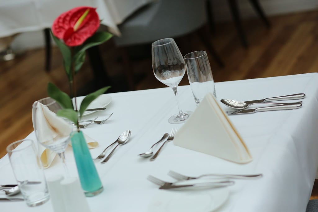 Ein eingedeckter Tisch wartet in einem Restaurant auf Gäste.
