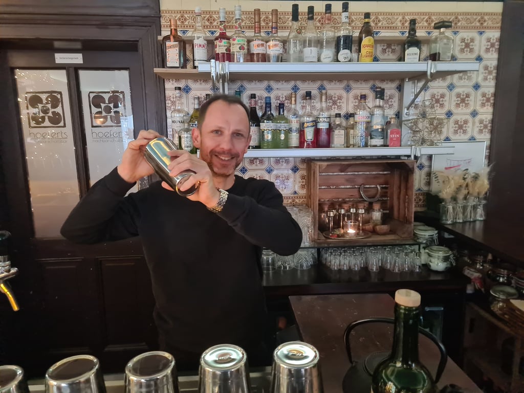 Barmeister Aron Bucholz in der Magdeburger "Hoeferts Nachbarschaftsbar" beim Mixen eines Cocktails.