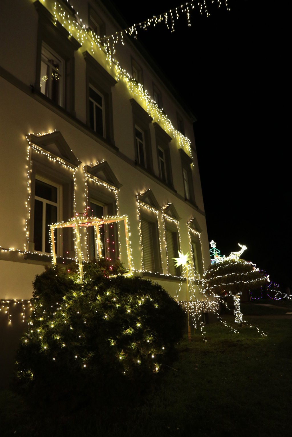 Ein Geschenk funkelt hier neben Stern und Weihnachtsschlitten.
