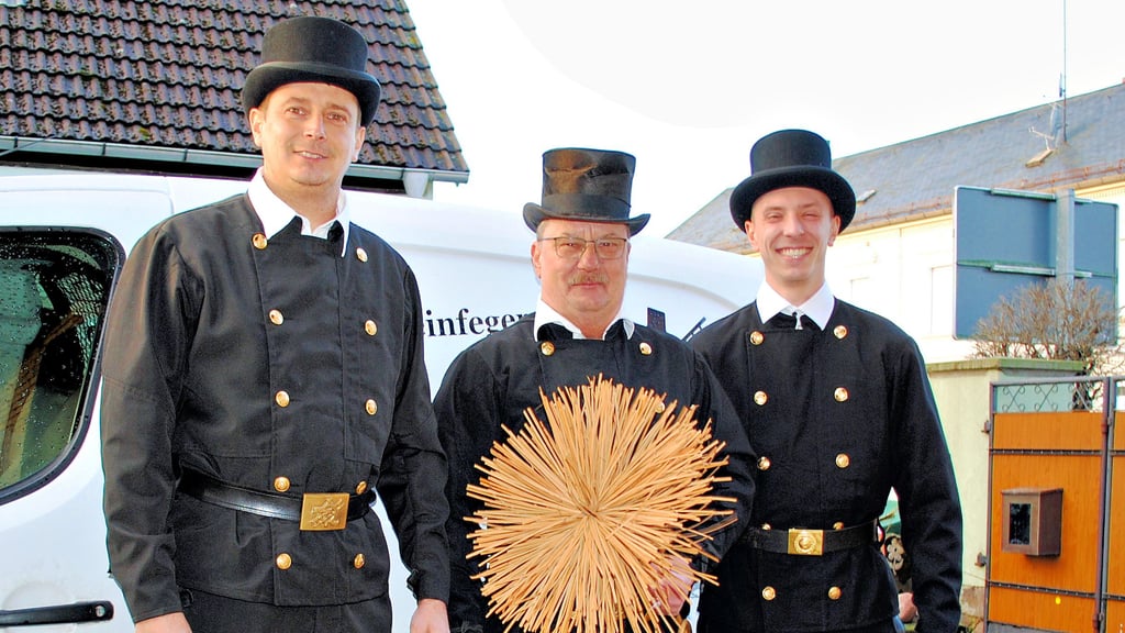 Präsentieren sich zur Übergabe des Kehrbesens in ihren Gala-Anzügen: Bastian Reschke (links) und Arik Müller nehmen Heiko Reschke in die Mitte. Der Kehrbezirk 5 (Kläden) bleibt in der Familie.
