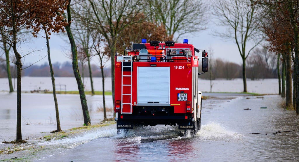 Ein Fahrzeug der Feuerwehr fährt auf einer teilweise überfluteten Straße unweit der Aller.