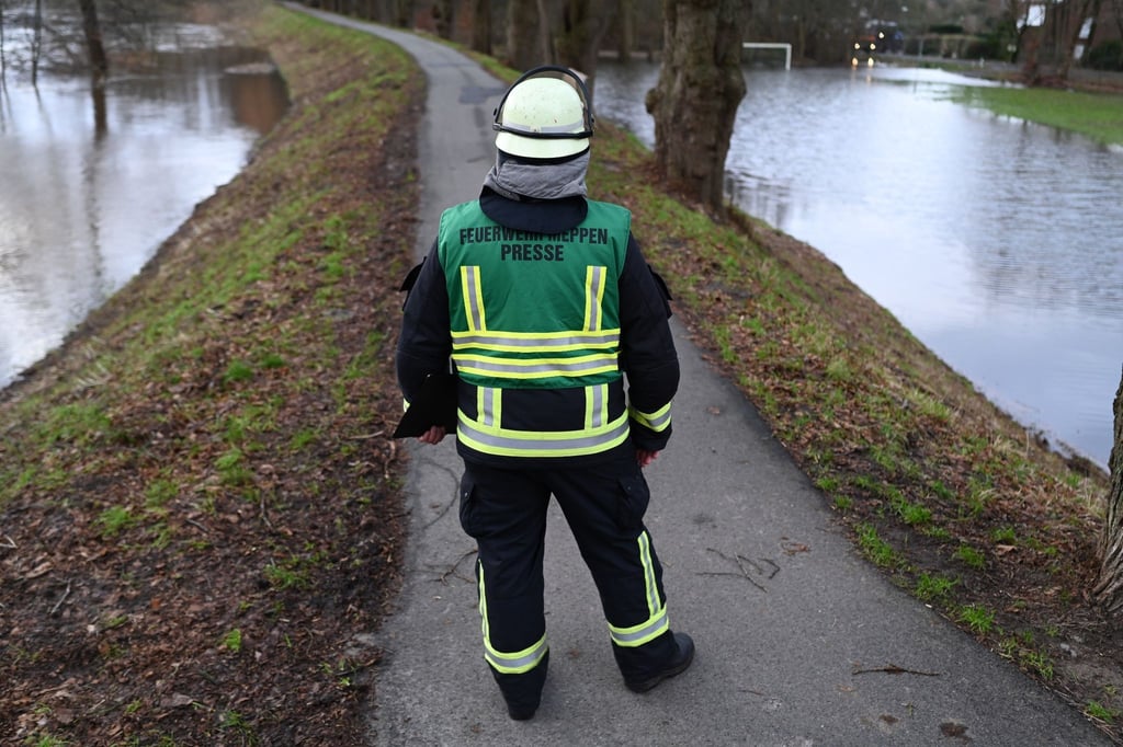 Feuerwehrmann Sven Lammers blickt auf den durchweichten Ems-Deich.