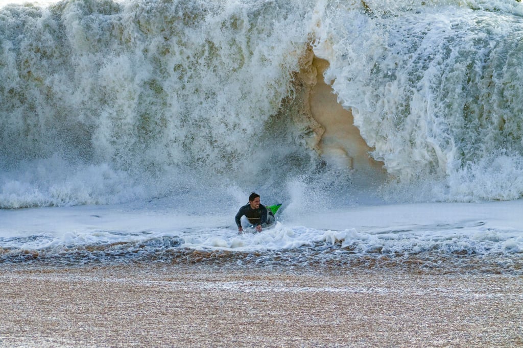 Ein Surfer taucht in Seal Beach aus den Wellen auf.