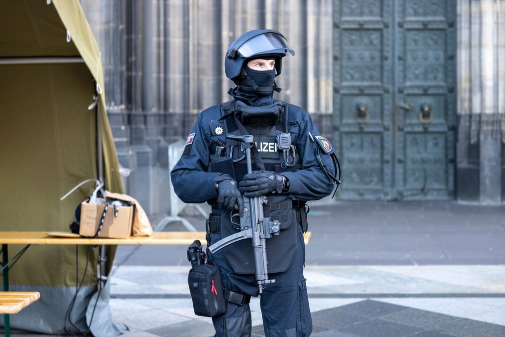 Vor dem Pontifikalamt im Kölner Dom zum Jahresabschluss mit Kardinal Woelki wird das Domumfeld von Einsatzkräften der Polizei mit Maschinenpistolen stark bewacht.