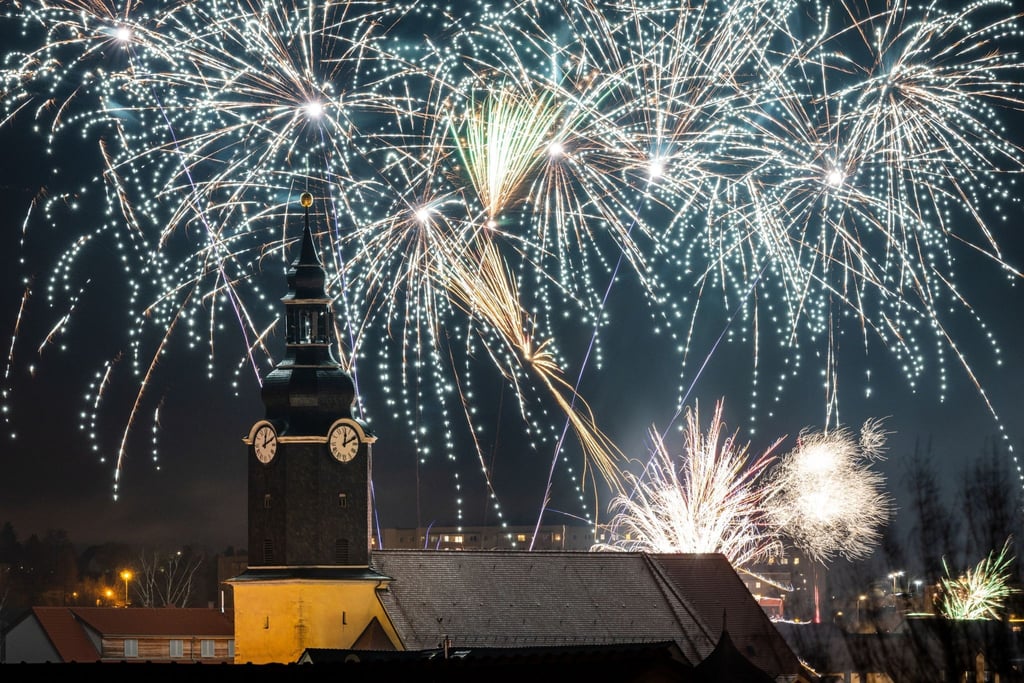Silvesterraketen ziehen ihre leuchtenden Spuren in den Nachthimmel um die St. Jakobuskirche.