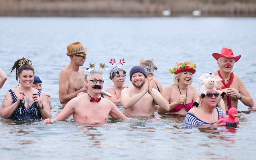 Kostümierte Winterschwimmer des Vereins "Berliner Seehunde" nehmen beim Neujahrsschwimmen im Orankesee ein Bad.