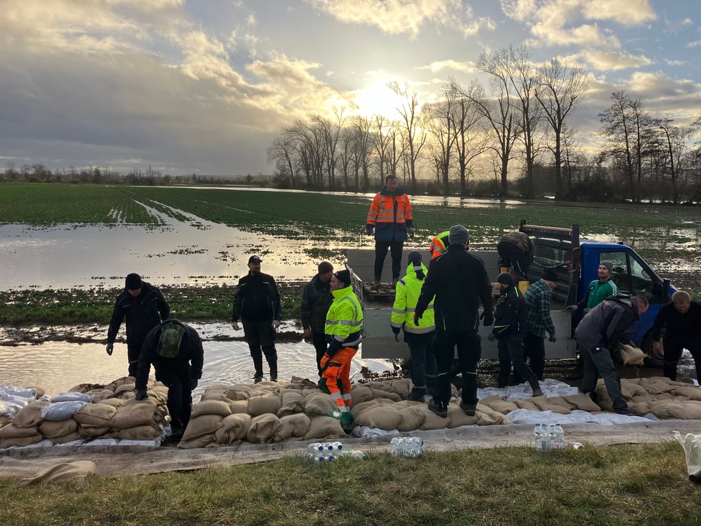 Der durchnässte Helme-Damm bei Martinsrieth wird mit Sandsäcken stabilisiert, damit er nicht abrutscht.