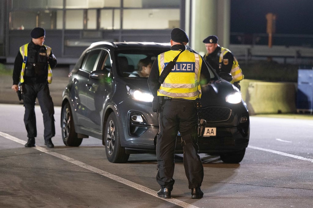 Polizisten stehen vor einem PKW.