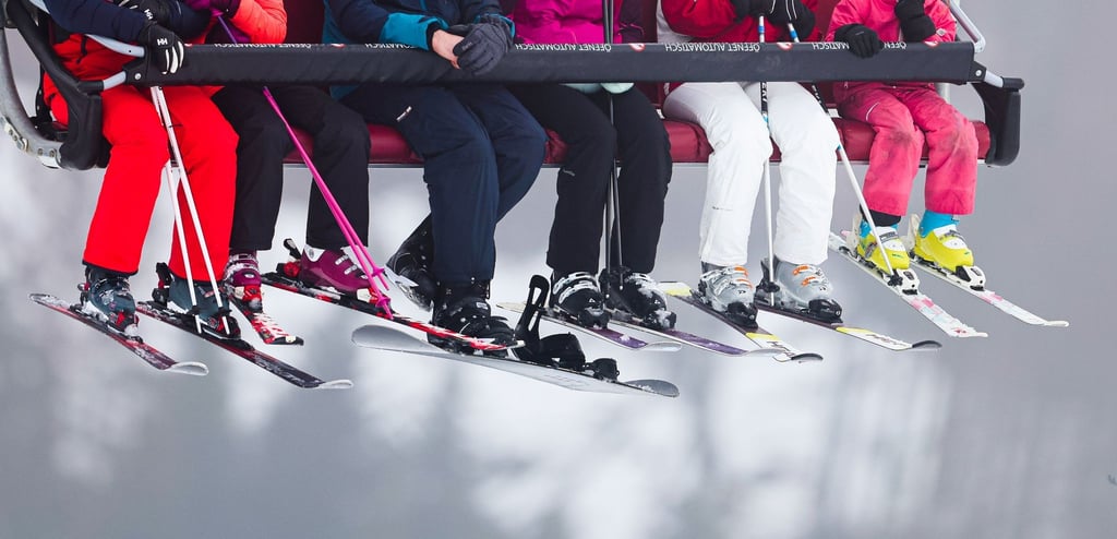 Skifahrer sitzen in einem Lift auf dem Weg zur Skipiste.